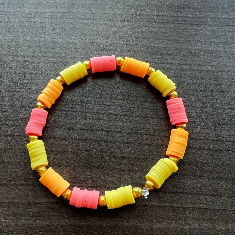Clay beaded bracelet orange, pink, and yellow and gold accents